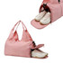 A pink duffle bag featuring a compartment for shoes, designed with a stylish handle and a zippered opening.