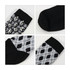 Four pairs of socks featuring different patterns, including a black and white design and an argyle pattern, with black sections.