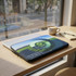 A small laptop sleeve featuring a vibrant design in green and blue, with a logo and text on the surface.