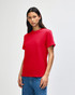 A red heavyweight cotton unisex T-shirt worn by a model, featuring a plain design and a logo.