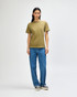 A unisex heavyweight cotton T-shirt in olive green, paired with light blue cargo pants. A logo is present.