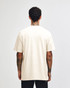 A cream heavyweight cotton unisex T-shirt displayed on a model, featuring short sleeves and a plain back.