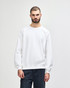 A white crewneck sweatshirt with long sleeves, featuring a relaxed fit and a simple design. It has a logo.