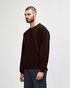A brown Gildan Heavy Blend adult crewneck sweatshirt worn by a model, paired with blue jeans. The sweatshirt has a simple design.