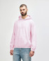 A man wearing a pink Gildan Heavy Blend adult hooded sweatshirt with a front pocket and hood.