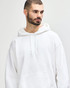 A white Gildan Heavy Blend adult hooded sweatshirt is worn by a young man adjusting the hood. The product features a logo.