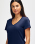 A navy Gildan Softstyle ladies' V-neck T-shirt displayed on a model, featuring a fitted design and short sleeves.