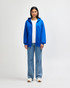 A blue Gildan Heavy Blend adult full zip hooded sweatshirt on a model, paired with light jeans and white shoes.