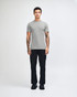 A grey unisex short sleeve t-shirt displayed on a model wearing loose-fitting denim jeans and sneakers.