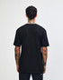 A person wearing a black unisex short sleeve t-shirt, viewed from the back, with a slight curl in the hair.