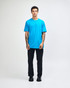 A man wears a bright turquoise unisex fine jersey short sleeve T-shirt, with a logo on the shirt.