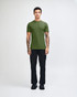A green unisex short sleeve t-shirt worn by a model, paired with blue jeans and black shoes. Branding visible.