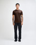 A unisex fine jersey short sleeve T-shirt in olive green, worn with light blue jeans. The model stands casually with hands in pockets.