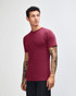A unisex fine jersey short sleeve t-shirt in burgundy, featuring a logo, displayed on a male model from the side.