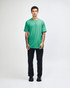 A model wearing a turquoise unisex fine jersey short sleeve t-shirt paired with khaki pants. The shirt has a logo.