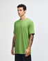 A green unisex short sleeve t-shirt displayed on a model from the side, featuring a branding logo.