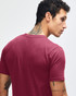 A maroon American Apparel fine jersey short sleeve T-shirt displayed on a model from the back, featuring a logo.
