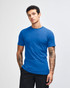 A blue short sleeve T-shirt on a model with tattoos, featuring a logo on the shirt.