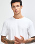 A white unisex short sleeve t-shirt displayed on a model paired with black leggings and white sneakers.