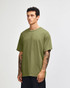 A model wearing an olive green unisex heavyweight cotton T-shirt. The shirt has a relaxed fit and short sleeves.