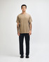 A unisex heavyweight cotton T-shirt in earthy brown, worn with light blue jeans and dark sneakers.