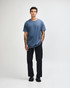 A navy unisex t-shirt made of heavyweight cotton, modelled by a person wearing light cargo jeans.