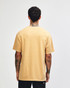 A unisex garment dyed heavyweight cotton t-shirt in a warm beige colour, viewed from the back. Features a logo.