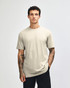 A unisex short sleeve T-shirt in a neutral beige colour, displayed on a model. It features a simple design and logo.