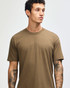 A unisex short sleeve t-shirt in a muted brown colour, displayed on a model. Features a logo.