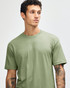 A green unisex CVC short sleeve T-shirt is displayed on a model with a neutral background. It features a logo.