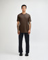 A unisex short sleeve T-shirt in brown, displayed by a model, paired with dark cargo pants and footwear.