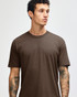 Unisex short sleeve t-shirt in brown, featuring a simple design and a logo on the fabric.