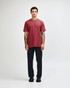A maroon unisex CVC short sleeve t-shirt worn by a model, paired with black cargo pants. The model has a casual stance.