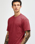 A unisex CVC short sleeve t-shirt in a deep red colour, displayed on a model with a neutral background.
