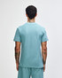 A green mockneck unisex T-shirt featuring a back view of the garment. It has a logo.