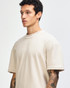 A beige unisex mockneck T-shirt displayed on a model with short sleeves and a relaxed fit. Features a logo.