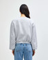 A women's crewneck sweatshirt in grey, featuring a relaxed fit and long sleeves, visible from the back.