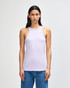 A women's racerneck tank in lavender, featuring a fitted silhouette and a logo. The model is wearing loose-fitting jeans.