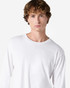 A white long sleeve t-shirt featuring a logo, worn by a model with curly hair.