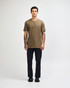 A unisex henley T-shirt in olive green, paired with light blue baggy jeans, displayed on a model.