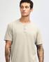 A unisex henley t-shirt in a light beige colour, featuring three buttons at the neckline and short sleeves.