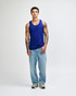 A unisex fine jersey tank in blue, paired with black cargo pants and green and white sneakers. Features a branding logo.