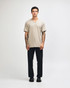 A beige unisex V-neck T-shirt, featuring a relaxed fit and short sleeves, with a branding logo present.