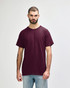 A maroon Gildan Heavy Cotton Adult T-Shirt on a model, featuring short sleeves and a round neck, with a logo.