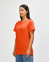 An orange Gildan Heavy Cotton adult T-shirt displayed on a male model. The shirt has a simple design and features a logo.