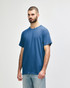 A blue Gildan Heavy Cotton adult t-shirt displayed on a model, featuring a simple design and a logo.