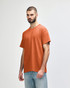 A plain orange adult t-shirt featuring a round neck and short sleeves, displayed on a model.