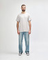 A grey Gildan Heavy Cotton adult T-shirt displayed on a person, paired with light blue jeans and black shoes.