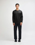 A black Super Heavyweight T-Shirt paired with loose blue jeans and black sneakers, displayed on a model.