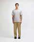 A grey American Apparel Super Heavyweight T-Shirt displayed on a model, paired with light blue jeans and sneakers.